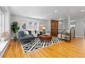 Open-concept living area with hardwood floors, stylish furnishings, and a decorative wood accent wall at 4451 Eliot St, Denver, CO 80211
