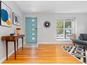 Bright living room featuring hardwood floors, a modern front door, and abundant natural light at 4451 Eliot St, Denver, CO 80211