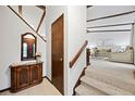 Welcoming foyer with wooden accents, tiled floors, and a view of the carpeted stairs and living room at 4677 S Wolff St, Denver, CO 80236