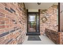 Inviting brick entryway with a screen door and a decorative wreath at 4677 S Wolff St, Denver, CO 80236