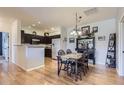 Open-concept dining area featuring hardwood floors, classic dining set, and stylish decor at 8445 S Holland Way # 205, Littleton, CO 80128