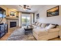 Bright living room with a cozy fireplace, plush sectional sofa and a sliding glass door with a balcony at 8445 S Holland Way # 205, Littleton, CO 80128