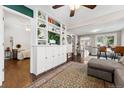 Open concept living room with stylish built-in shelving and views into the dining area and bedroom at 1253 Uinta St, Denver, CO 80220