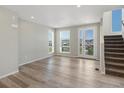 Open-concept living room featuring hardwood floors, natural light, and seamless access to the staircase and outdoors at 3654 Penang Dr, Castle Rock, CO 80109