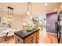 Open concept kitchen features a center island with black countertops and hardwood flooring at 453 S Quay Street, Lakewood, CO 80226