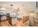 Kitchen with central island with a black countertop, wooden cabinets, and a dining table with a stairwell nearby at 453 S Quay Street, Lakewood, CO 80226