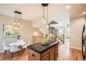 Bright kitchen with center island, hardwood floors, stainless steel appliances, and access to the stairs at 453 S Quay Street, Lakewood, CO 80226