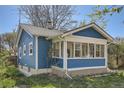 A charming side view of the home showcasing its blue siding and bright white sunroom at 2252 S Lafayette St, Denver, CO 80210
