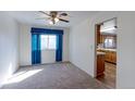 Open living area with ceiling fan, carpeted floors, and access to the kitchen at 9202 W Virginia Pl, Lakewood, CO 80226