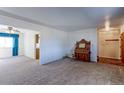 Spacious living room with neutral carpet, a piano, and open access to kitchen and entryway at 9202 W Virginia Pl, Lakewood, CO 80226