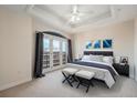 Bedroom with tray ceiling, access to a balcony, and neutral decor creating a serene atmosphere at 1827 N Grant St # 1104, Denver, CO 80203