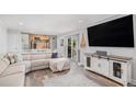 Open living room with hardwood floors, walkout, and media center at 92 Helena Cir, Littleton, CO 80124