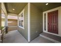 Cozy covered porch with stone accents and a classic red front door at 19782 W 59Th Ave, Golden, CO 80403