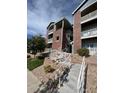 A beautiful brick building with a well-maintained lawn and stairs with white railings at 2705 S Danube Way # 304, Aurora, CO 80013