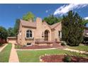 Charming brick home featuring unique architectural details, a clay tile roof and a well-manicured front lawn at 1615 Locust St, Denver, CO 80220