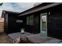 Modern house exterior featuring black brick, a green door, and minimalist landscaping at 1560 S Forest St, Denver, CO 80222