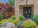 Stone townhouse entrance with chairs, stone address plaque, and colorful landscaping at 2741 Java Ct, Denver, CO 80211