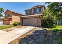 Two-story home with an attached garage, a driveway, and green lawn at 1371 W 133Rd Way, Denver, CO 80234