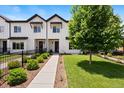 Charming exterior with black trim, showcasing the property's curb appeal and landscaped front yard at 3103 S Cherokee St, Englewood, CO 80110
