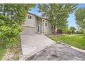 Inviting home with a two-car garage, long driveway, and mature shade trees at 11029 Grouse Ct, Parker, CO 80134