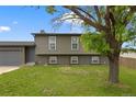Charming two-story home with a well-maintained lawn and attached garage with a gray exterior elevation at 18396 E Mexico Pl, Aurora, CO 80017