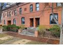 Attractive brick townhouse boasts a symmetrical facade, decorative iron fencing, and manicured landscaping at 1748 W 36Th Ave, Denver, CO 80211