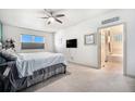 Bright bedroom with a ceiling fan, en-suite bathroom, and a cozy, carpeted floor at 1155 S Balsam St, Lakewood, CO 80232