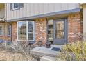 Welcoming front entrance featuring a brick exterior, bay window, and inviting gray door at 8862 E Amherst Dr # D, Denver, CO 80231