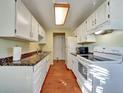 Efficient kitchen with white cabinets, faux marble countertops, and all-white appliances at 17505 E Mansfield Ave # 1411L, Aurora, CO 80013