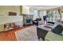 Cozy living room with a stone fireplace, wooden floors, and sliding door access to the outside at 17505 E Mansfield Ave # 1411L, Aurora, CO 80013