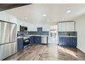 Modern kitchen features two-tone cabinets, stainless steel appliances, and hardwood floors throughout at 5050 Steele St, Denver, CO 80216