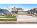 Spacious two-story home with a three-car garage, stone accents, well-manicured lawn, and a covered front porch at 18103 House Finch Ln, Parker, CO 80134