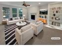 Bright living room with fireplace, built-in bookshelves, and large windows, showcasing modern decor at 24955 E Roxbury Pl, Aurora, CO 80016
