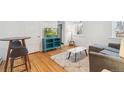 Cozy living room with a blue cabinet, television, and a gray couch at 1581 N Ogden St, Denver, CO 80218