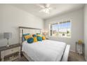 Bright bedroom with large window and white furniture with accent pillows at 985 Penstemon Dr, Henderson, CO 80640