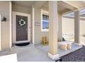 A welcoming front porch with pillars and a decorative wreath on the front door at 985 Penstemon Dr, Henderson, CO 80640