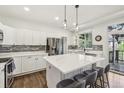 Bright kitchen features a large center island with marble countertops and stainless steel appliances at 7513 Simms Ct, Arvada, CO 80005
