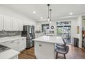 Bright kitchen features a large center island with marble countertops, stainless steel appliances, and access to the back deck at 7513 Simms Ct, Arvada, CO 80005
