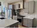 Modern kitchen featuring gray cabinets, stainless steel appliances, and a white countertop island at 1284 Osceola St, Denver, CO 80204