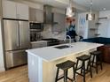 Bright, modern kitchen with stainless steel appliances, white countertops, and seating at the island at 1284 Osceola St, Denver, CO 80204