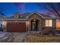 House exterior at dusk with stone accents and a two-car garage at 6321 Spring Gulch St, Frederick, CO 80516