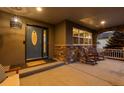 Inviting front porch with stone accents, rocking chairs, and a decorative front door with glass detail at 5322 Devils Head Cir, Golden, CO 80403