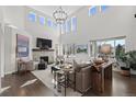 Bright, spacious living room with soaring ceilings, stone fireplace, and large windows with natural light at 5322 Devils Head Cir, Golden, CO 80403