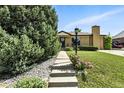 Beautiful brick home featuring mature trees, flowers, and a well-manicured lawn at 380 E 111Th Pl, Northglenn, CO 80233