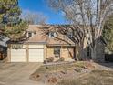 Charming two-story brick home with a three-car garage and mature trees in a desirable neighborhood at 6141 W Evans Pl, Lakewood, CO 80227
