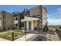 Charming townhome with stone accents, covered porch, and manicured landscaping at 6864 Bryant Ct, Denver, CO 80221