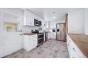 Bright kitchen featuring white cabinetry, stainless steel appliances, and butcher block countertops at 2095 Newland St, Edgewater, CO 80214