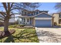 Charming two-story home with a well-manicured lawn, stone accents, and a cozy front porch at 11753 Elizabeth Cir, Thornton, CO 80233