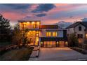 Modern two-story home with a two-car garage and ample lighting at dusk at 942 S Fulton St, Aurora, CO 80247