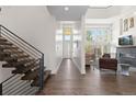 Bright foyer featuring hardwood floors, a modern staircase, and an open view to the living room at 942 S Fulton St, Aurora, CO 80247